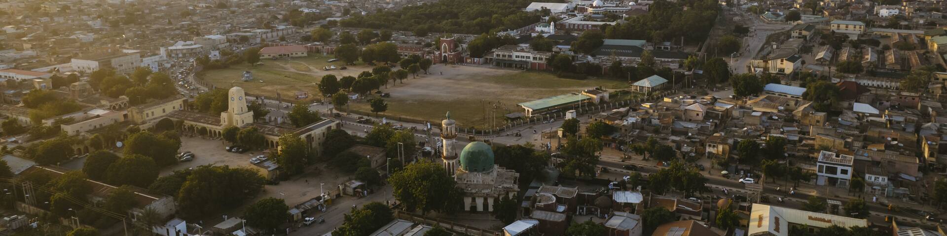 Aerial view of the Emir Palace Road area, with its buildings casting long shadows under the warm light, Kano, Kano, Nigeria.