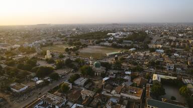 An aerial view of a city with a prominent church, a large green dome, and a mix of residential and commercial buildings.