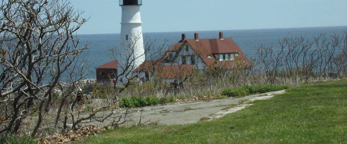 A lighthouse, a house, and a coastal landscape.