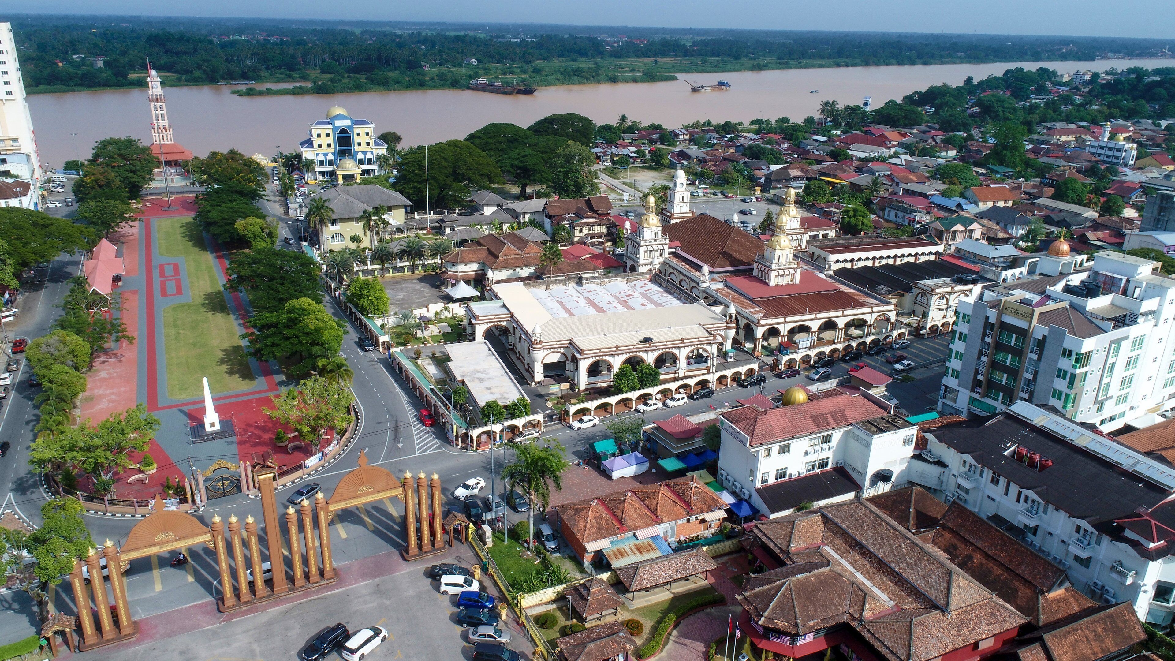An aerial view of a city with a prominent church, a river, and surrounding residential areas.