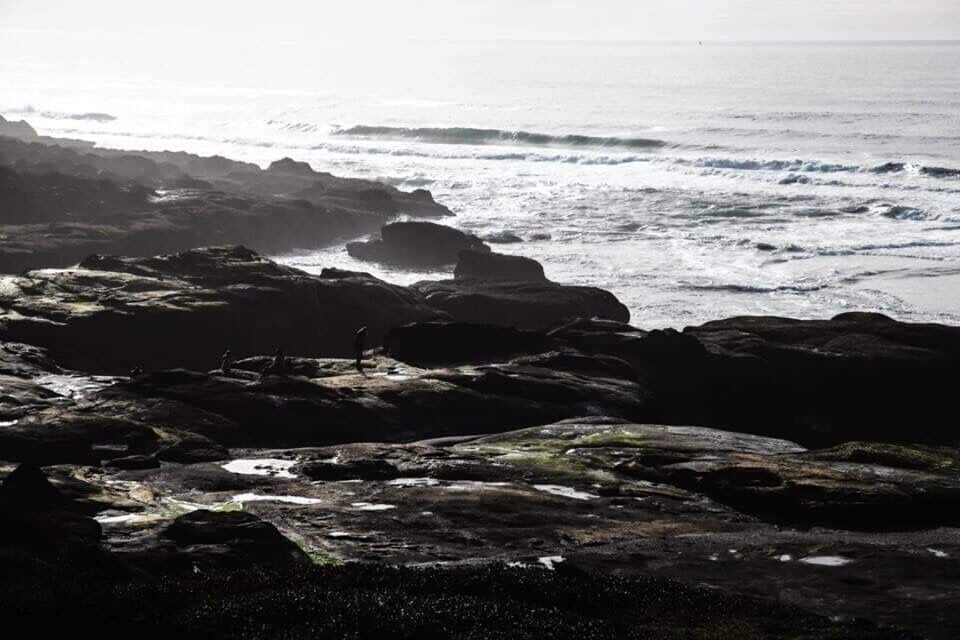Una costa rocosa con olas rompiendo contra las rocas.