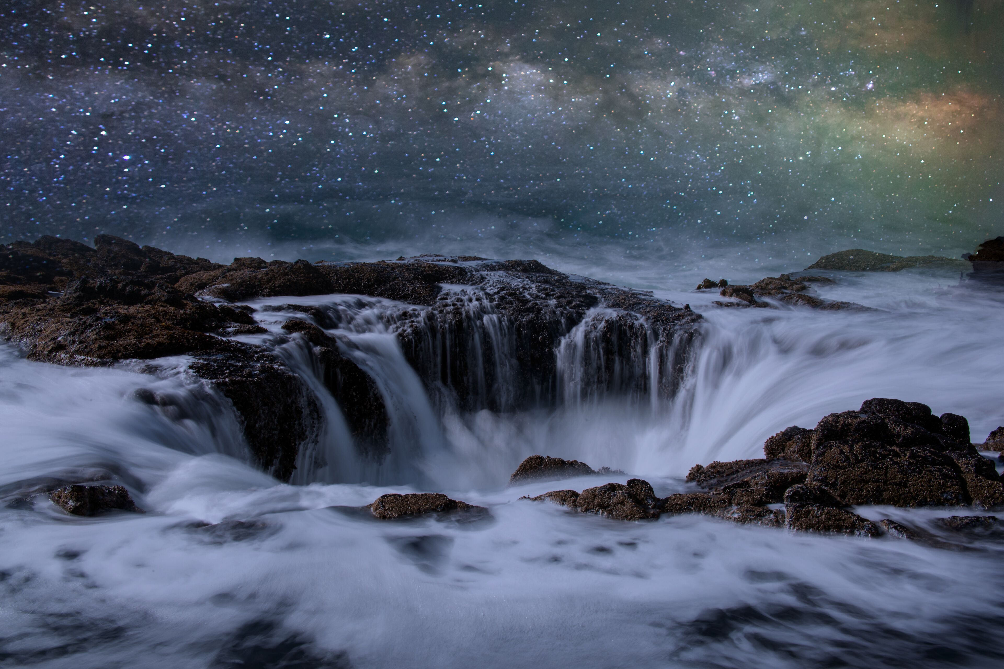 A waterfall with a starry night sky above.