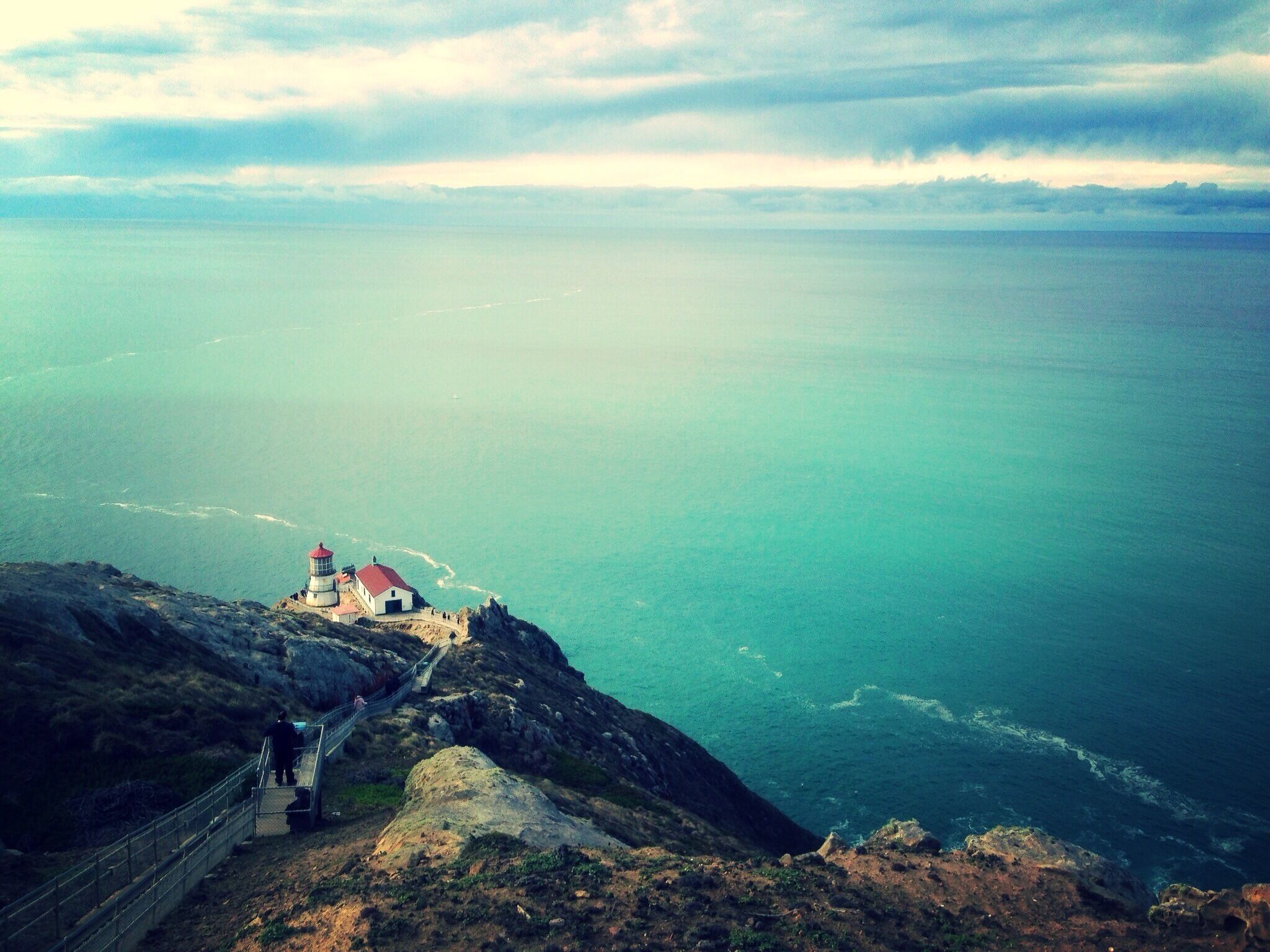 A lighthouse on a cliff overlooking the ocean.