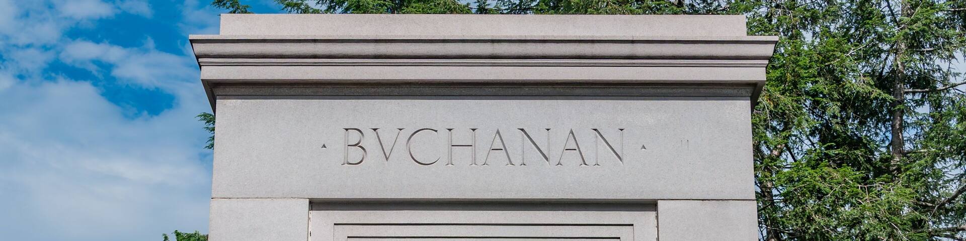 A statue of a seated man with a name plaque reading "BVCHANAN".