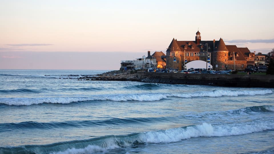 A coastal town with a historic stone building and a sea wall.