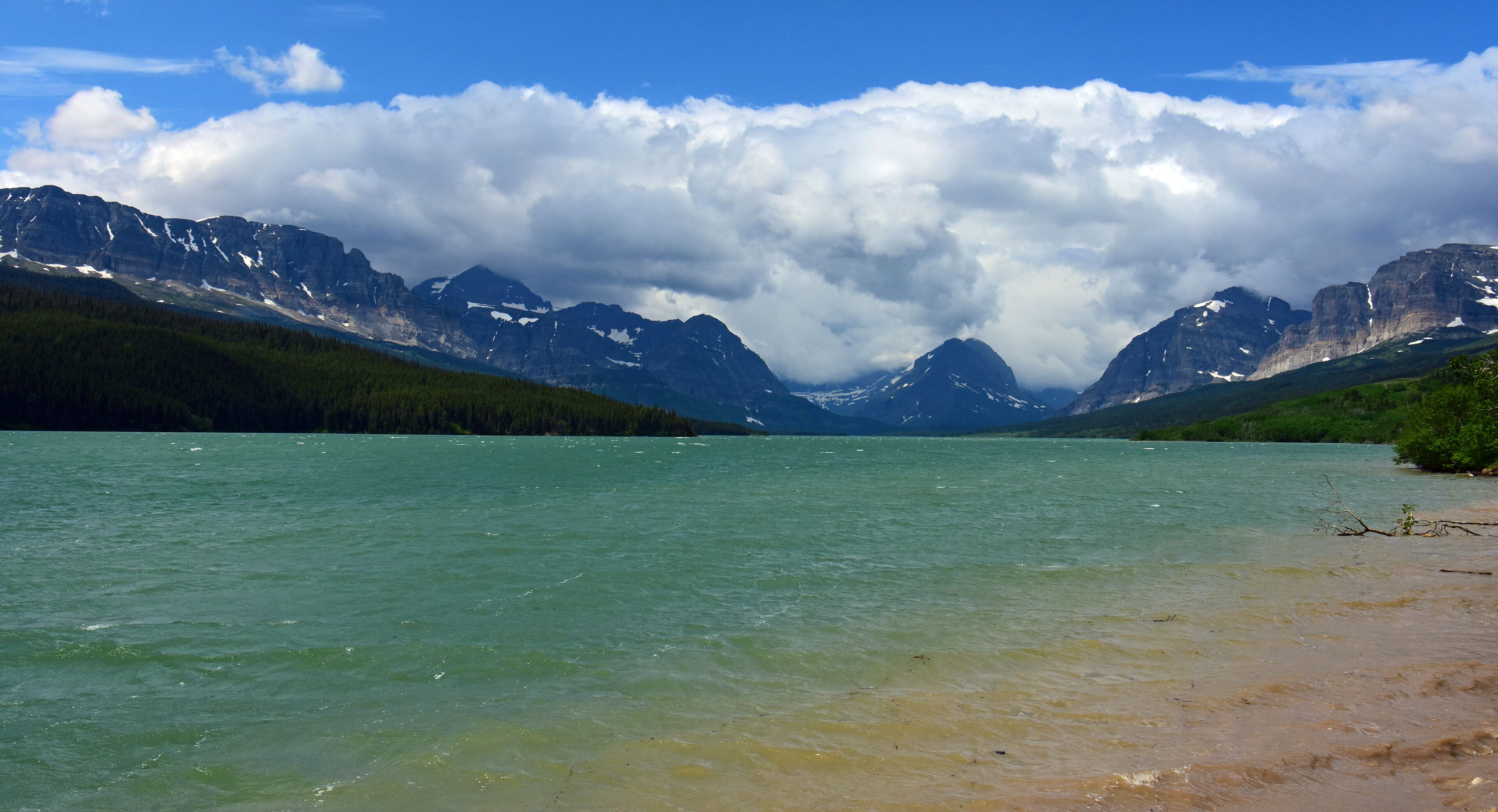 the turquoise-colored water of lake sherburne and   beautiful glaciated peaks of glacier national park, montana    