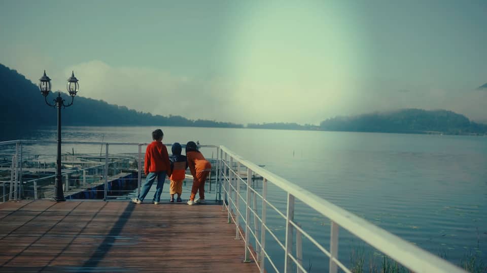A joyful family strolls on a scenic lake pier, surrounded by beautiful nature
