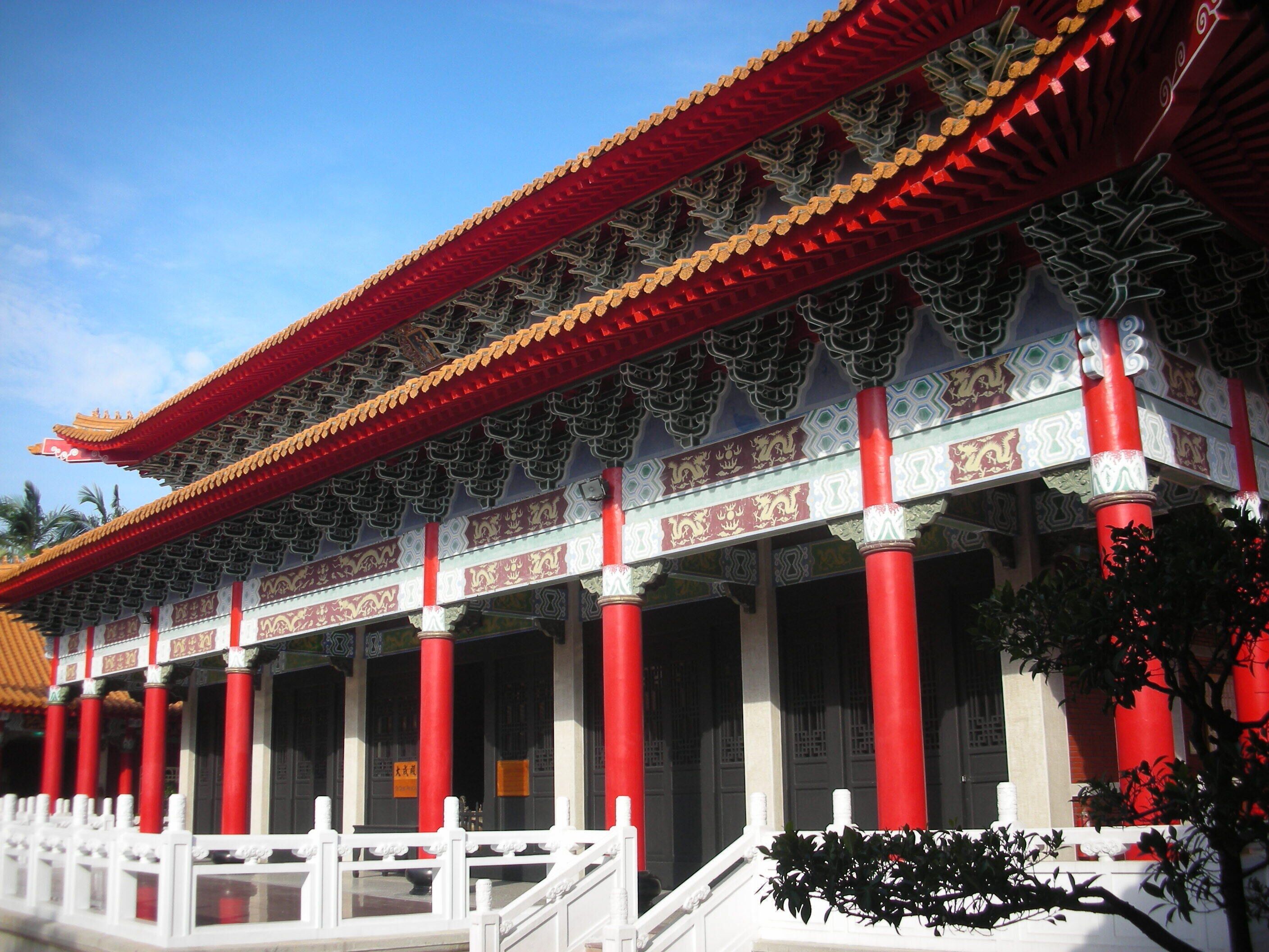 A traditional Chinese building with red columns and ornate roof tiles.
