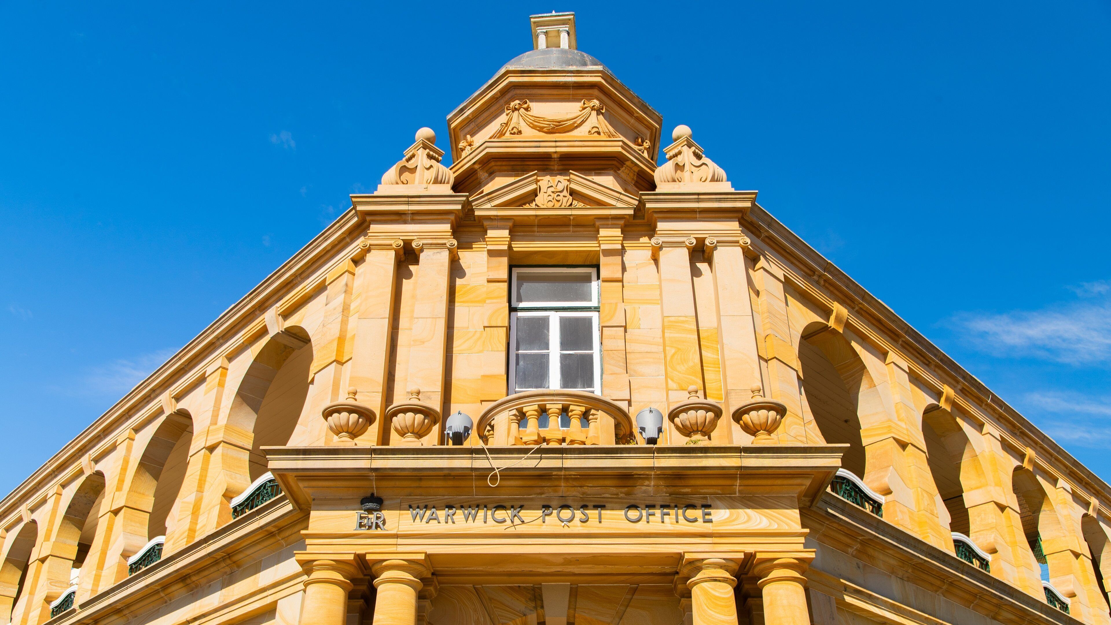 A historic building with a prominent entrance labeled "Warwick Post Office."