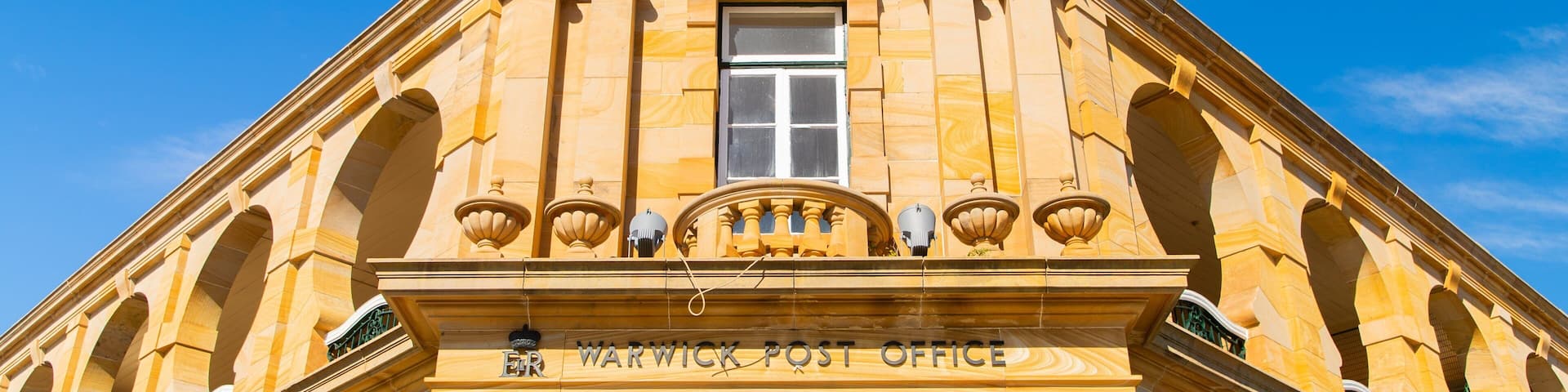 A historic building with a prominent entrance labeled "Warwick Post Office."