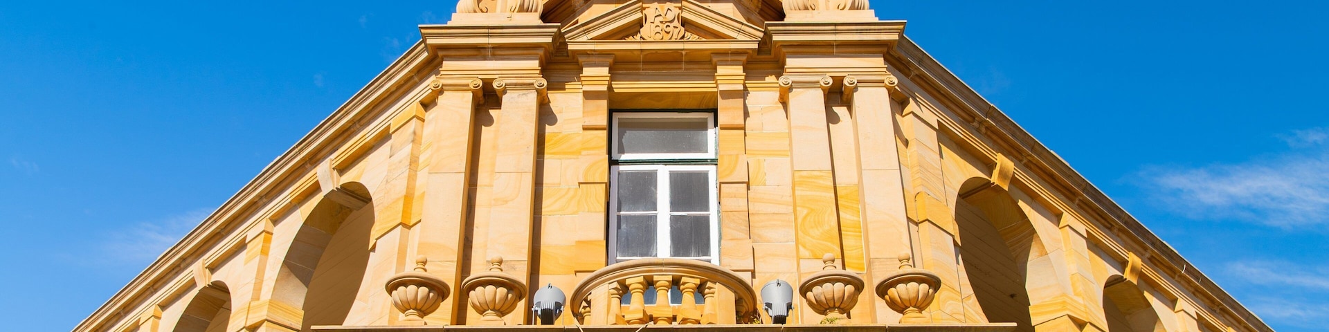 Un edificio histórico con una entrada destacada que muestra la inscripción 'Warwick Post Office'.