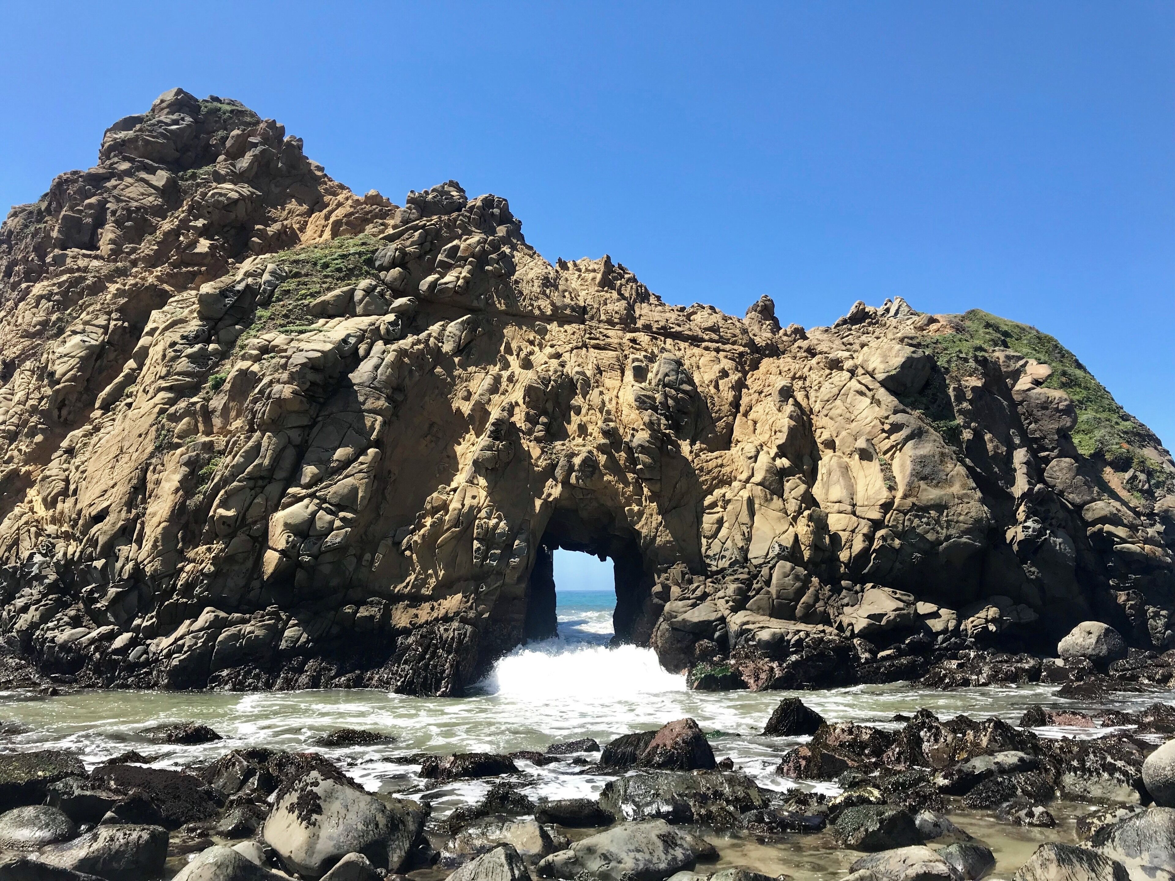 The Doorway Arch at Pfeiffer Beach in Big Sur. Warm sunshine, dark purple sand, and a few sea lions makes for a beautiful day at the beach.