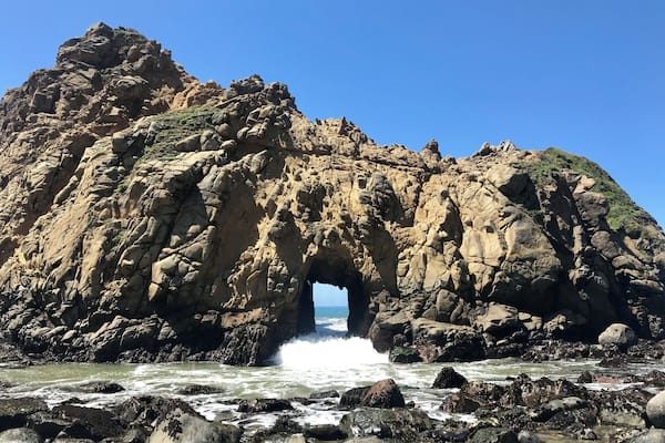 A rugged coastal rock formation with a natural archway.