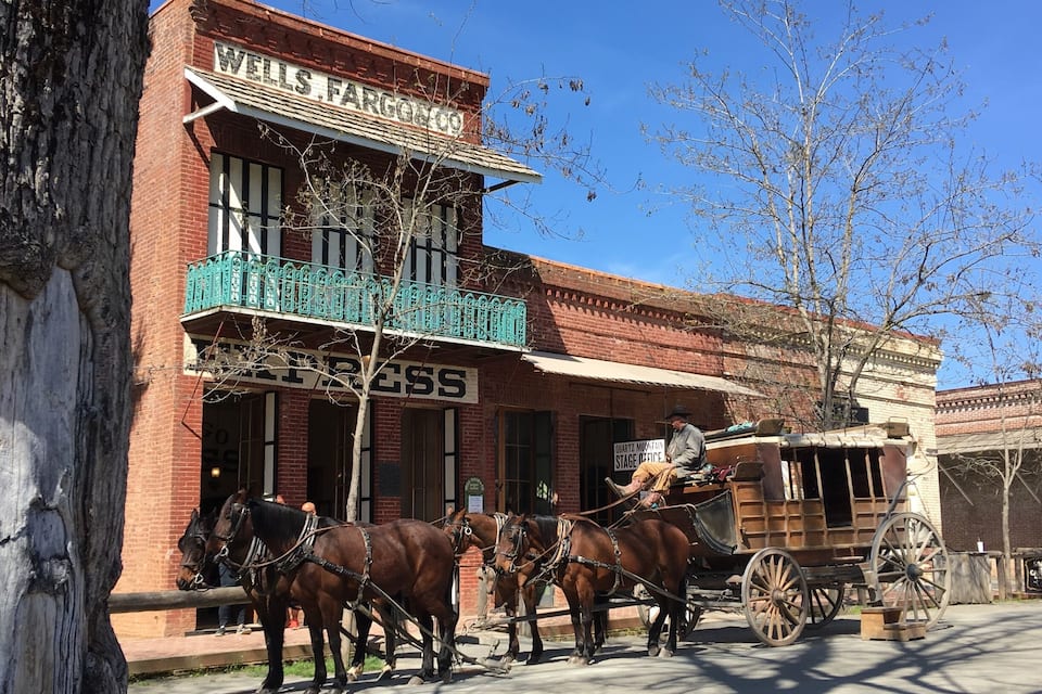 A Wells Fargo building with a horse-drawn carriage in front.