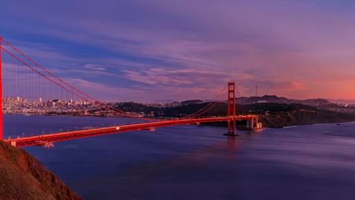 Panorama of the Golden Gate bridge with the Marin Headlands and San Francisco skyline at colorful sunset, California