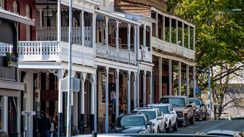 A street lined with historic buildings, parked cars, and a 'SPANISH ST' sign.