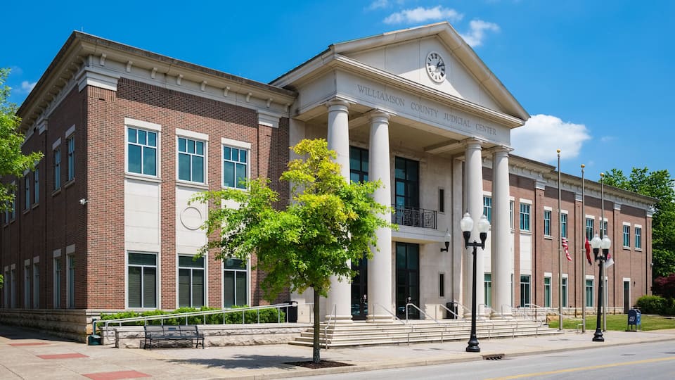 A courthouse with a clock tower, columns, and a brick facade.