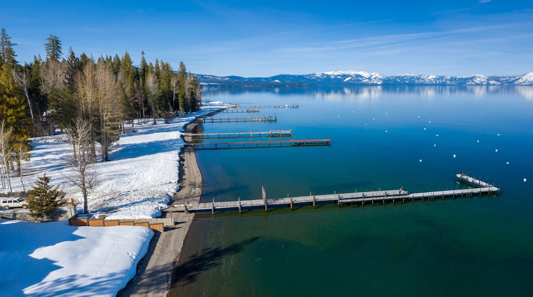 Pier, mountains with snow on calm Lake Tahoe, Homewood, California, United States of America.