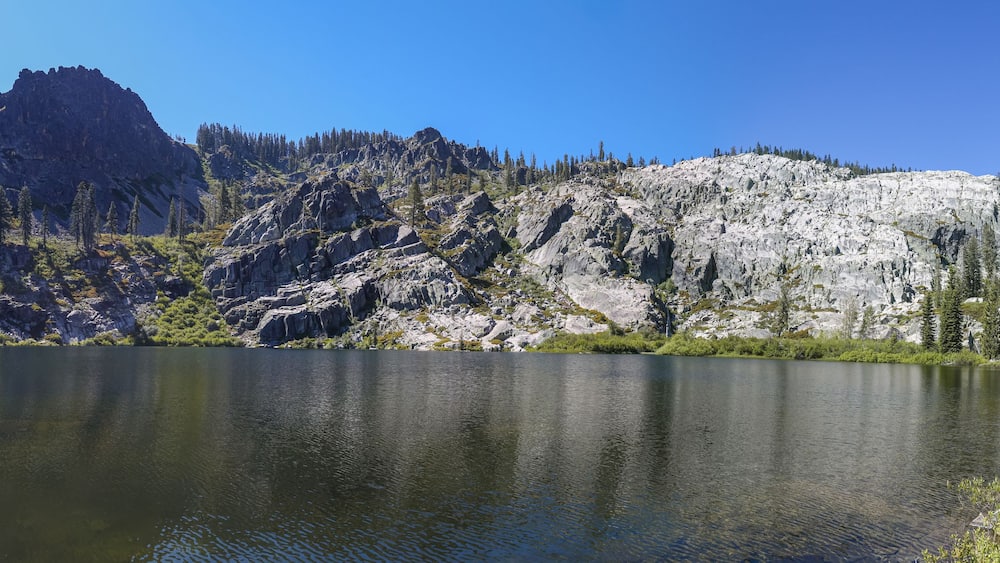 A mountain lake with rocky cliffs and trees.