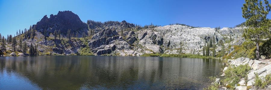 A mountain lake with rocky cliffs and trees.