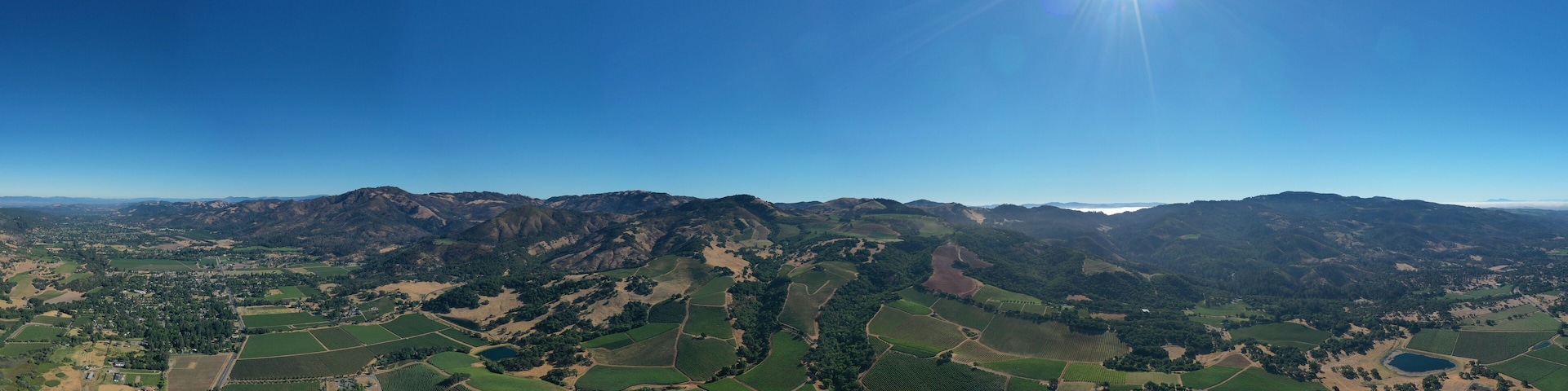 Un paysage montagneux, avec des vignobles en terrasses et un ciel d’un bleu limpide.