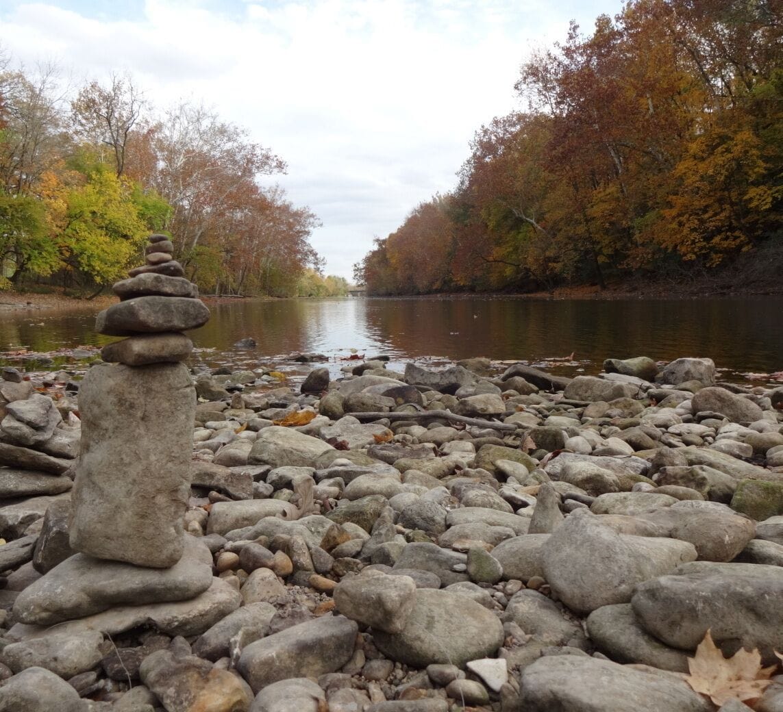 A cairn, the fall colors and the clouds reflecting off the calm water looking downstream of the Scioto River.