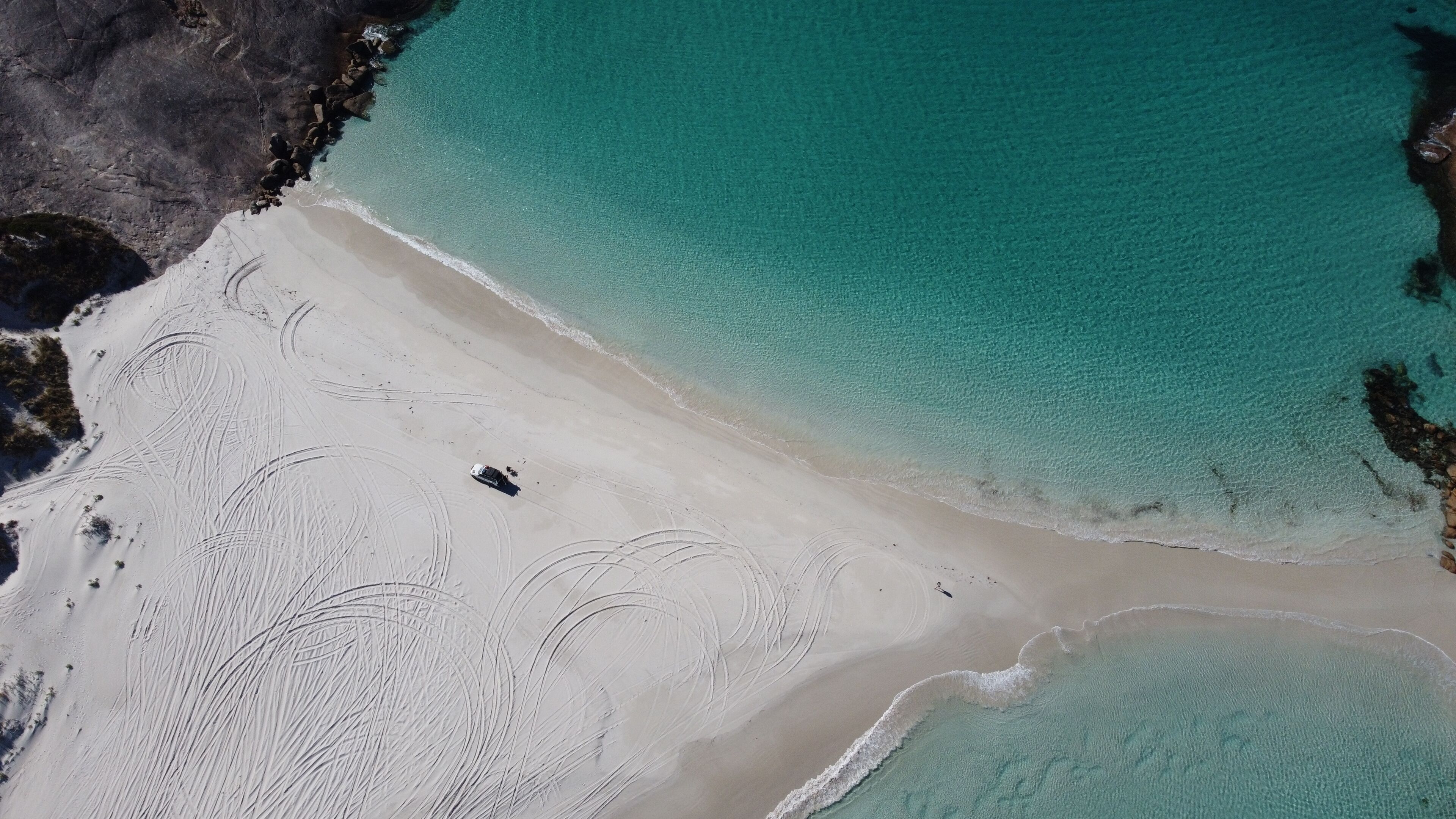 Aerial picture of Wylie bay in Esperance. Car parked on the beach. Blue and shallow water. Very beautiful and calm landscape. Driving on the sand in Australia.