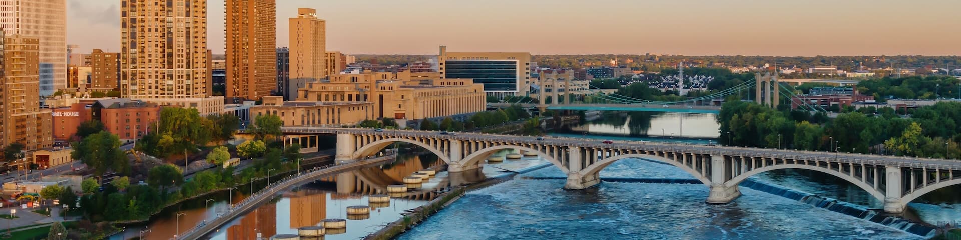 Minneapolis skyline at dawn, St. Anthony Falls dam, powerful water flow. City views, bridges, and the Mississippi River. Upper Pool, Minneapolis, Minnesota, United States