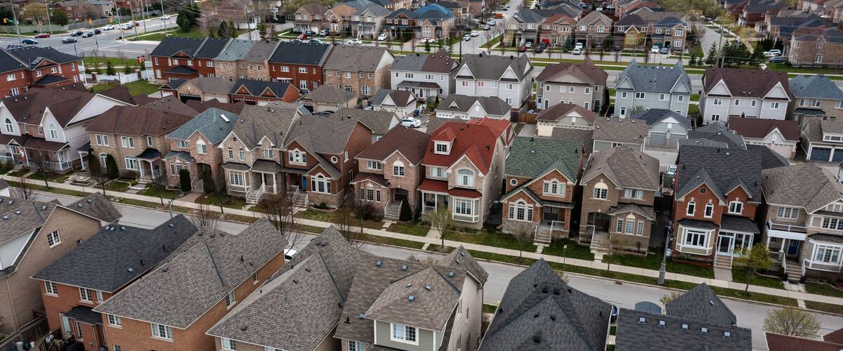 A residential neighborhood with houses, streets, and a distant city skyline.