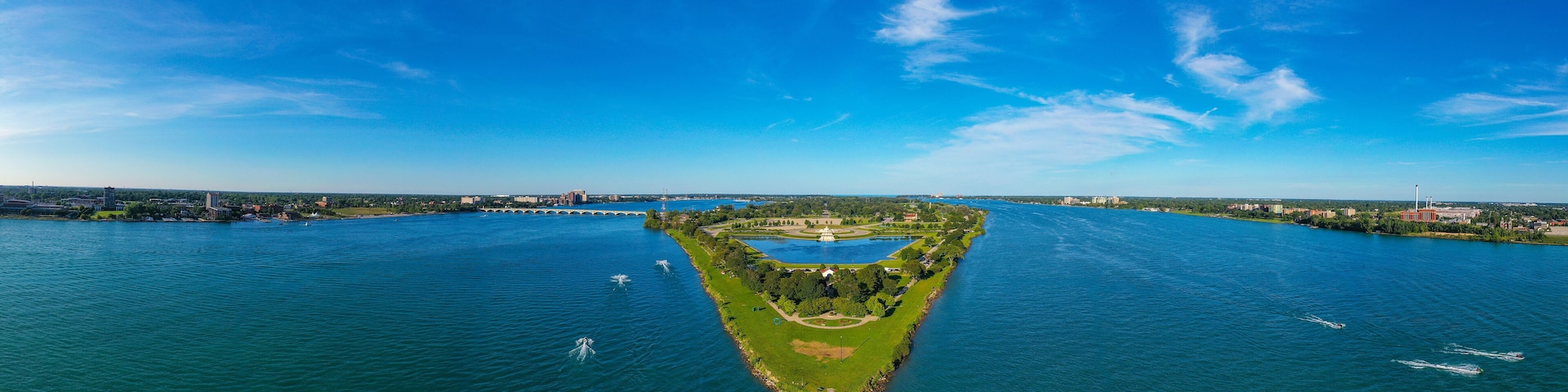 Looking towards the East, this aerial panoramic view shows the Western tip of Belle Isle below while showing Windsor, Ontario on the right and Detroit, Michigan on the left.