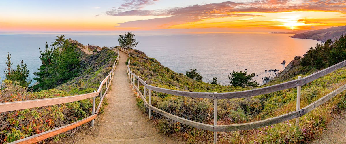 A coastal hiking trail with a sunset view.