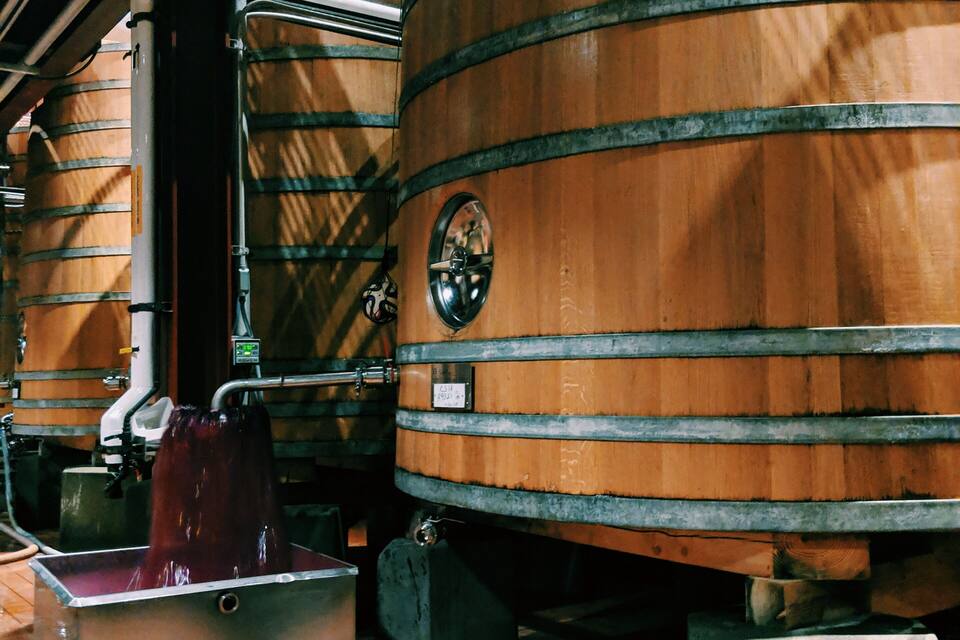 Large wooden fermentation tanks in a brewery.