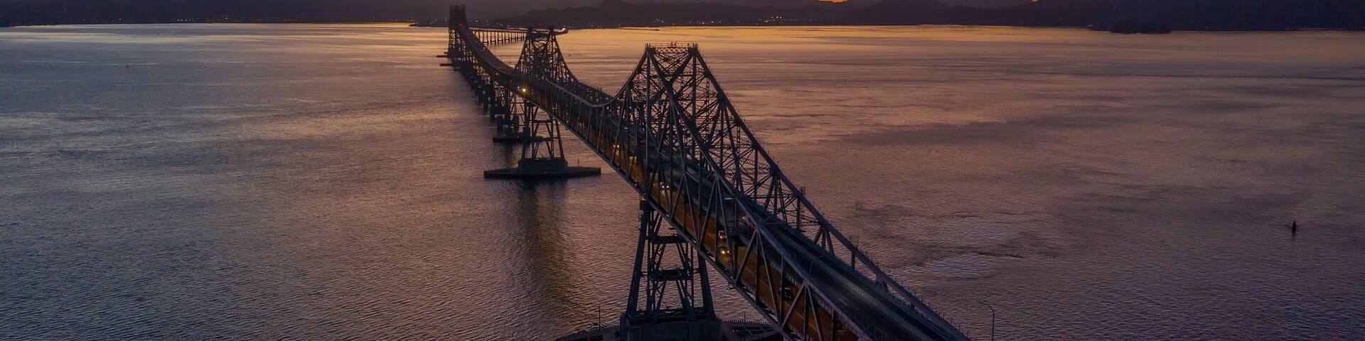 The Richmond-San Rafael Bridge spans San Pablo Bay in Richmond, California, USA, connecting counties. Cars travel across at sunset.