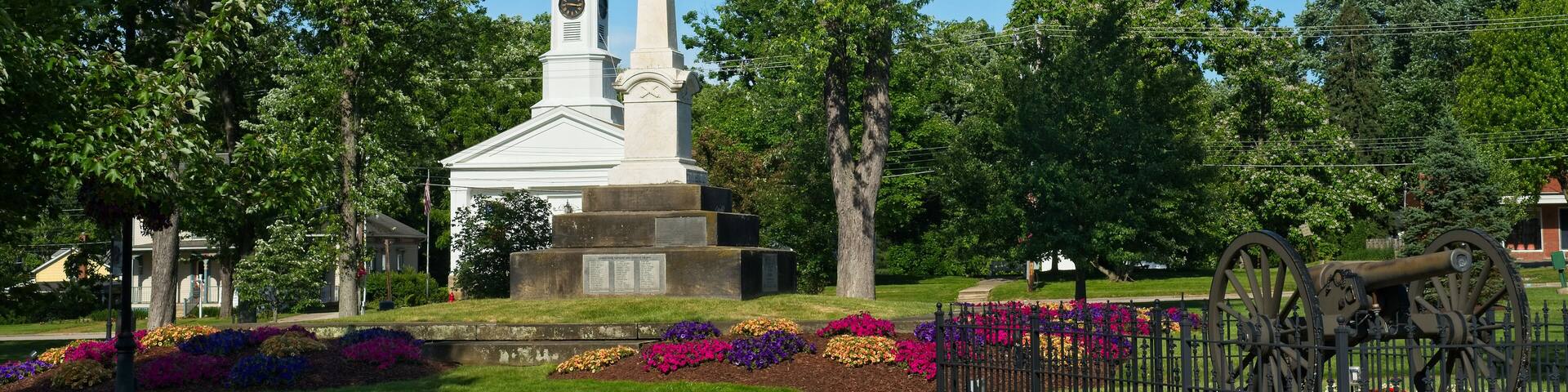Summer on Twinsburg Square with Civil War monument and cannon in front of a historic old church