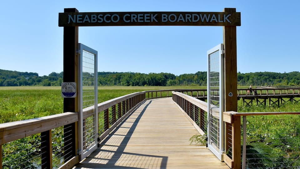 A boardwalk at Neabsco Creek with a wooden fence and a clear sky.