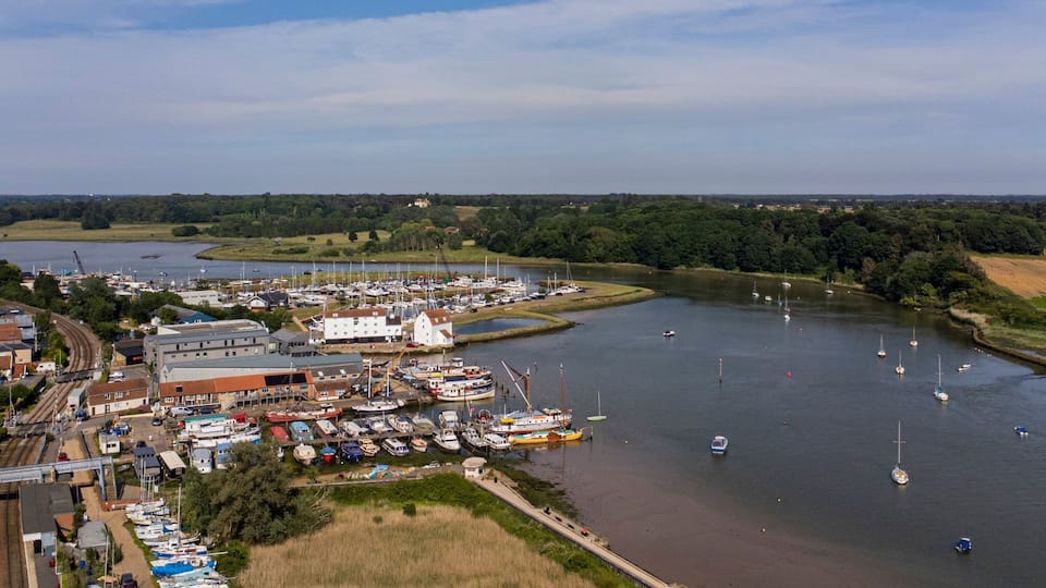 A riverside town with a marina, boats, and a bridge.
