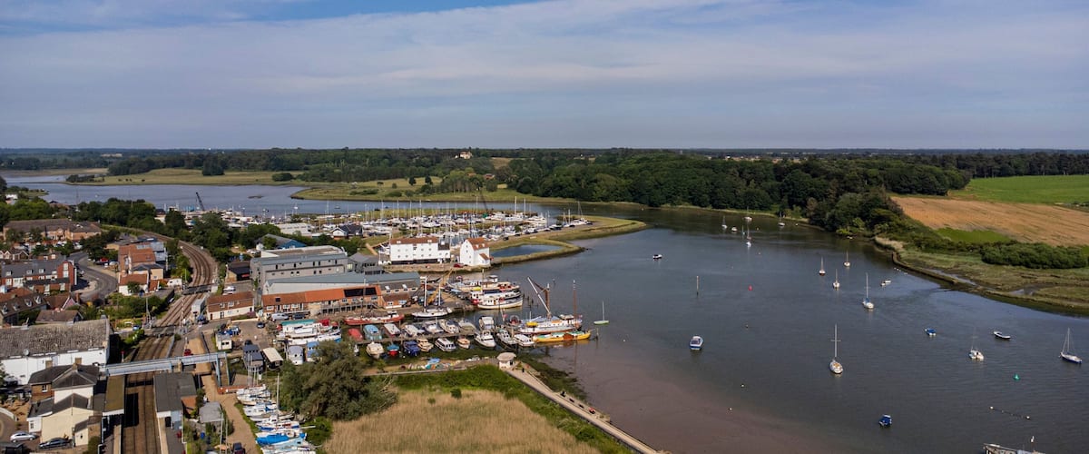 A riverside town with a marina, boats, and a bridge.