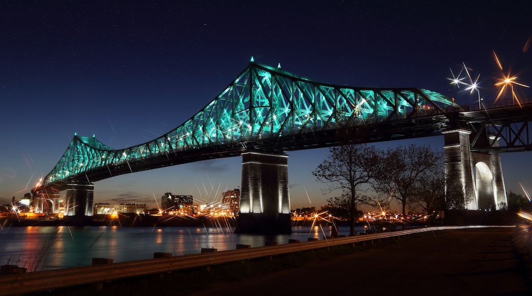 Jacques Cartier Bridge Illumination in Montreal, reflection in water. Montreal’s 375th anniversary. luminous colorful interactive Jacques Cartier Bridge. Bridge panoramic colorful silhouette by night.