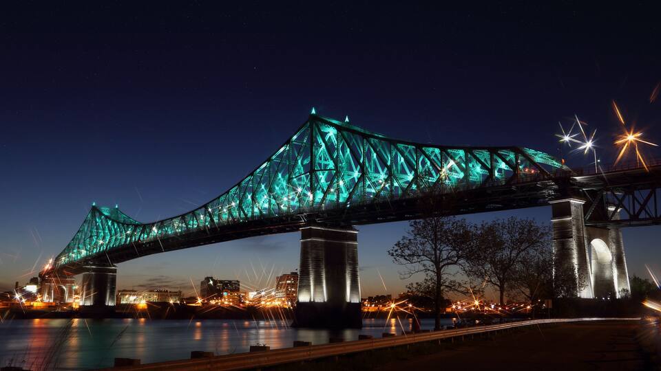 A bridge with illuminated blue lights at night.