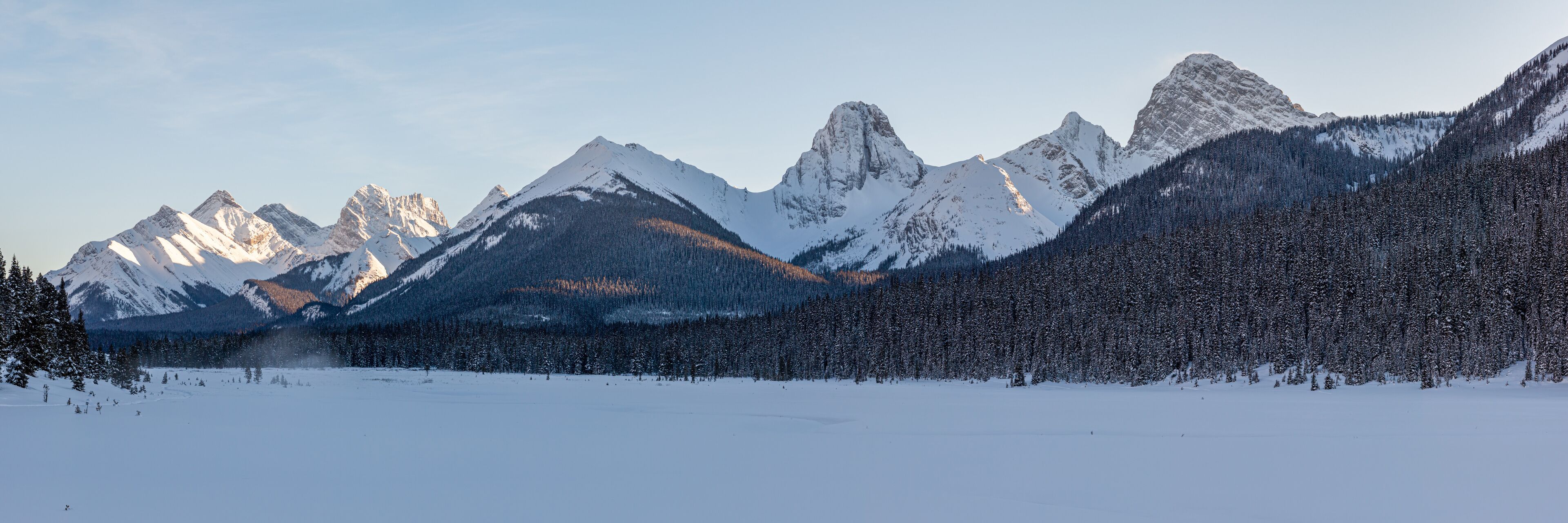 A snow-covered mountain range with a clear sky.