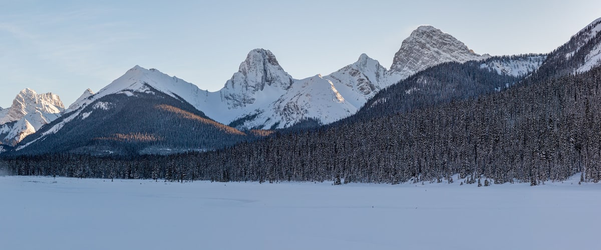 A snow-covered mountain range with a clear sky.