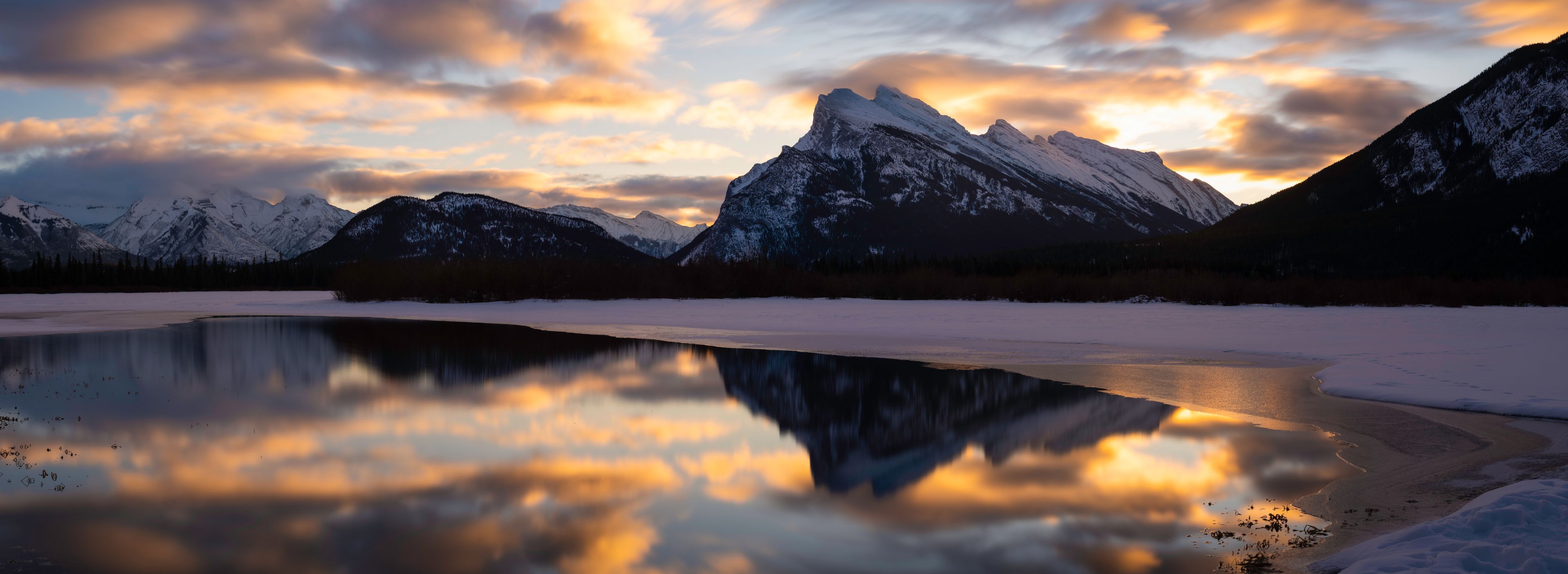 A panoramic view of Vermilion Lakes in Banff National Park during a Winter sunrise.