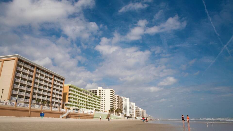 A beach with high-rise buildings and a clear sky.