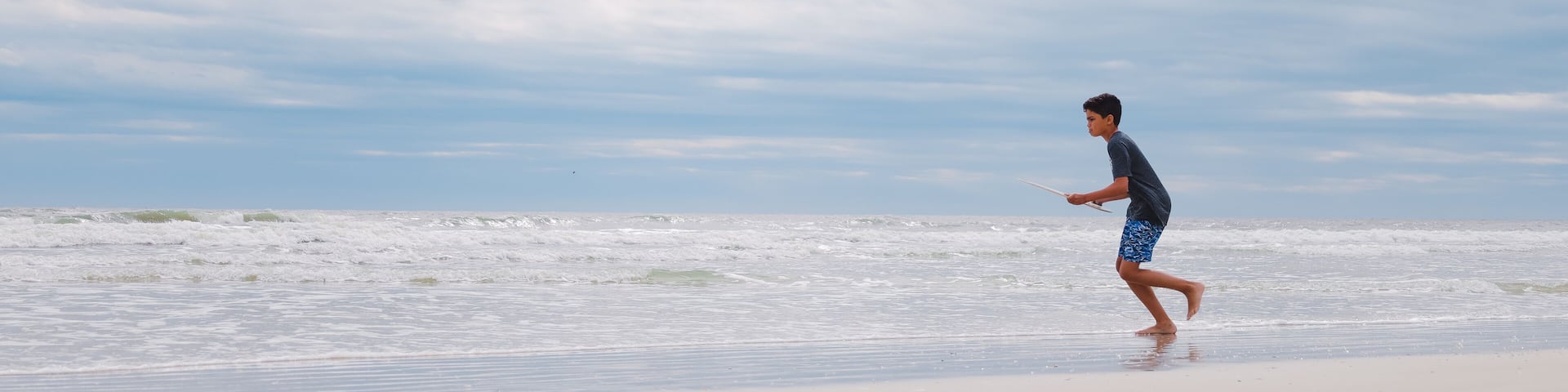 A beach with waves and a clear sky.