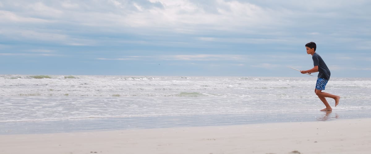 A beach with waves and a clear sky.