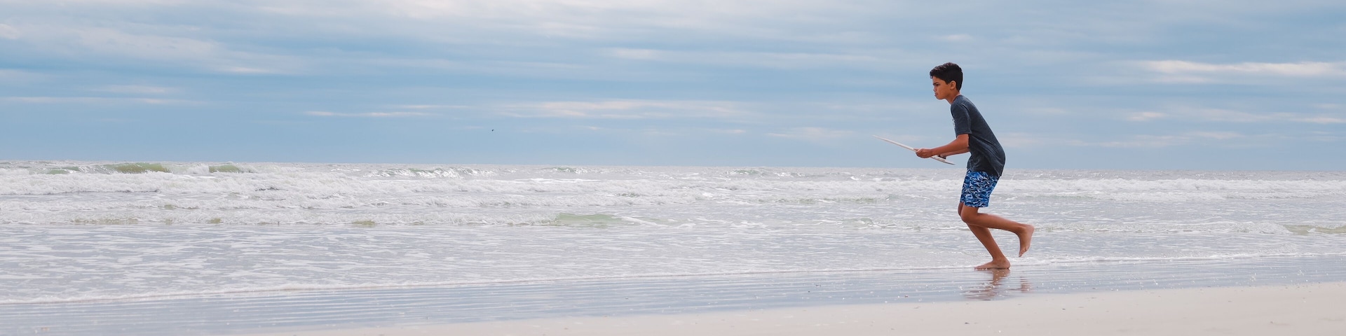 A beach with waves and a clear sky.