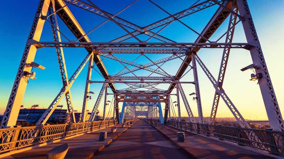 A steel bridge with a clear sky at sunset.