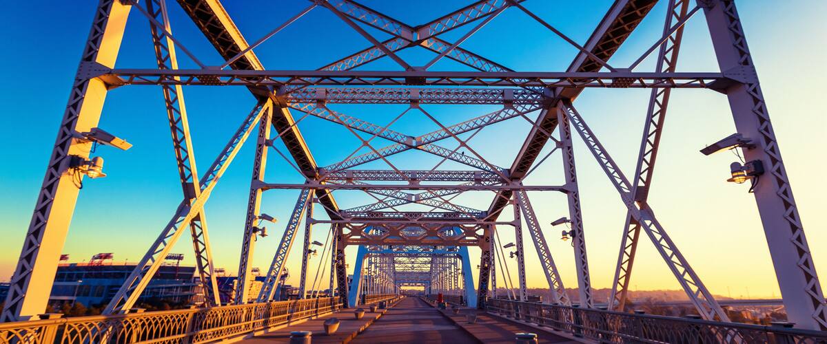 A steel bridge with a clear sky at sunset.