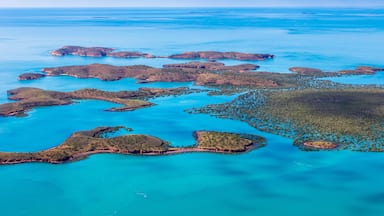 Vue aérienne d’une région côtière avec de nombreuses îles et des eaux d’un bleu limpide.