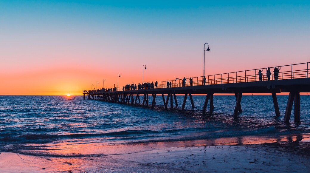 Glenelg Beach beach foreshore view with people walking along the pier at sunset, South Australia